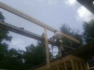 Carpenter setting a ridge beam over a new addition frame — Ice Dam Removal by Roofing Brothers in Fruitland